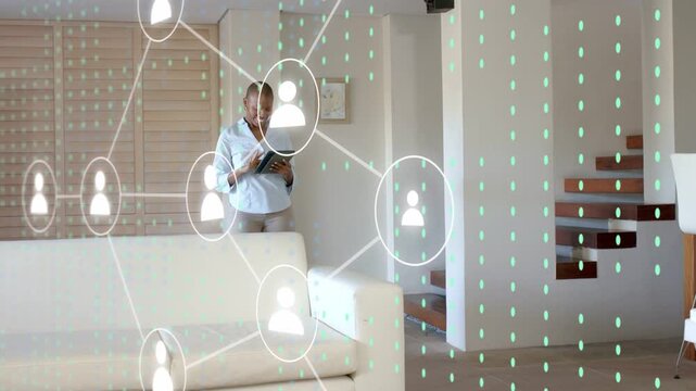 Man walking past sofa causing woman tapping tablet, expanding AR network mapping links across home