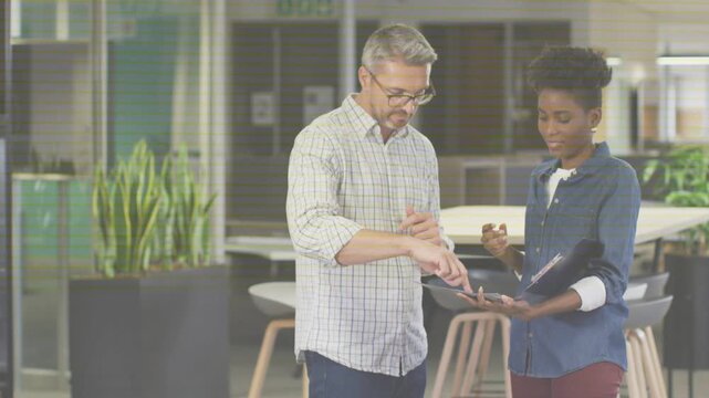 Man gesturing, coworkers reviewing folder, tracing items and checking wristwatch for business