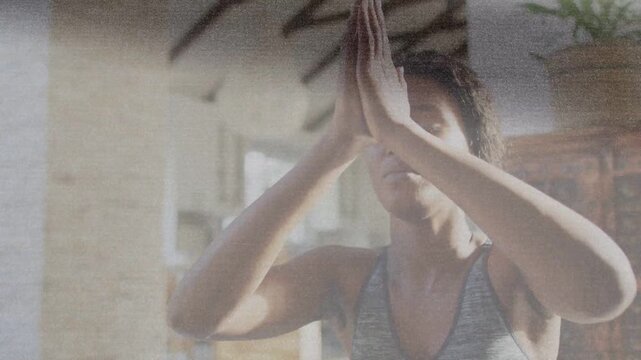 Woman inhaling, guiding palms to prayer in sunlit room, breath line tracing hands for wellness
