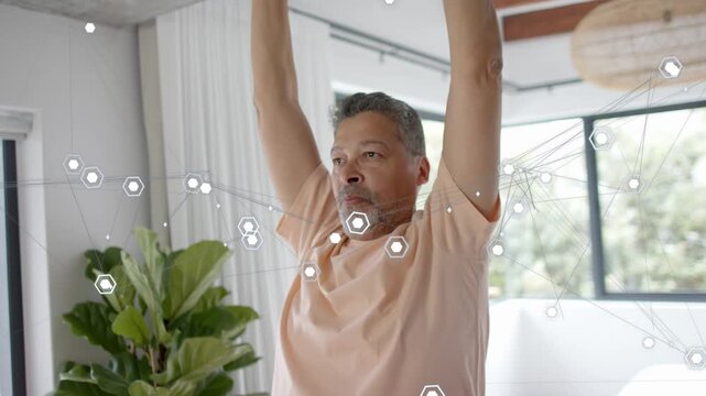 Mature man in home starting overhead lowering to shoulder T stretch for health hex grid parallaxing