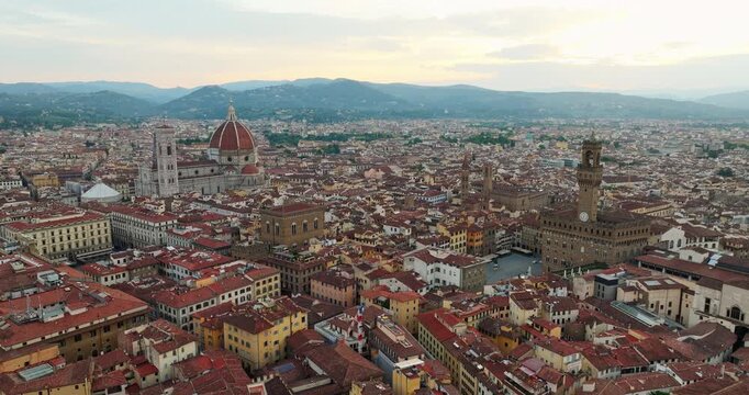 Florence Italy urban history drone view at sunrise. Detailed perspective Renaissance architecture buildings and medieval towers captured during summer trip exploration.
