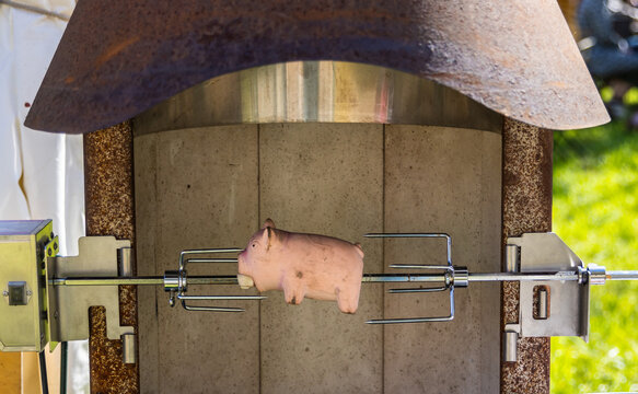 Eine Dekofigur vim Schwein auf einen Grill gesteckt