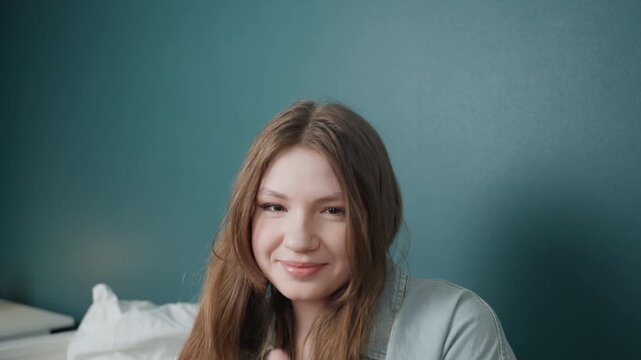 Vibrant cheerful portrait. Closeup of happy woman showing silly gestures. Portrait of youthful woman displaying humorous expressions against teal background with natural face makeup