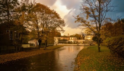 Obraz premium Serene Autumn Canal Reflecting Golden Trees and Cloudy Sky.
