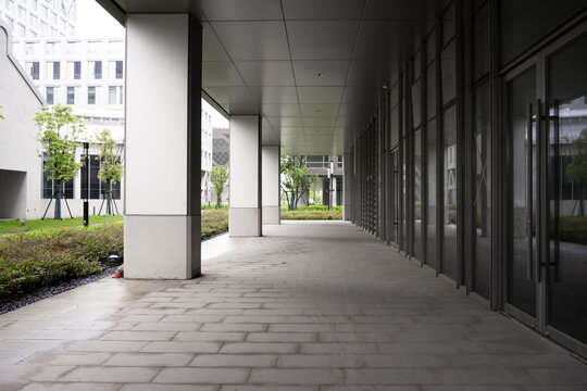Modern office building corridor with greenery landscape and paved walkway