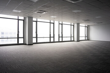 Naklejka premium Spacious modern office interior with floor-to-ceiling windows and minimalist design