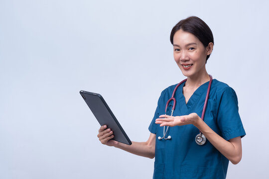 Asian female physician holding a blank tablet and gesturing with open hand. Perfect for medical app mockups or digital health ads. Isolated on white background.