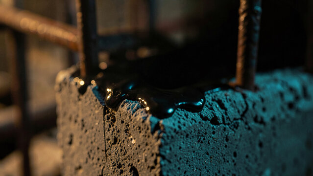 Dark dripping substance on rough concrete industrial texture