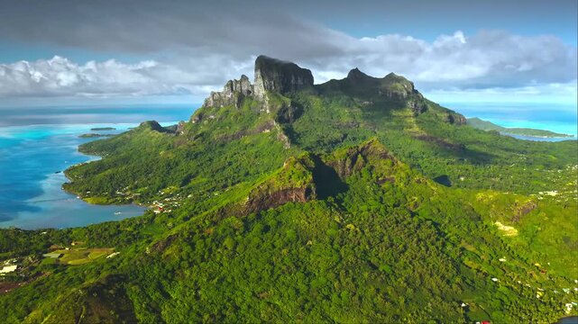 Lush green tropical volcanic mountain ridges under clear blue sky