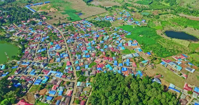 
View of Arunothai&rsquo;s Hills and Reservoir.
From a bird&rsquo;s-eye perspective, the vibrant rooftops of Arunothai Village form a colorful patchwork against the deep greens of the surrounding forested hills.