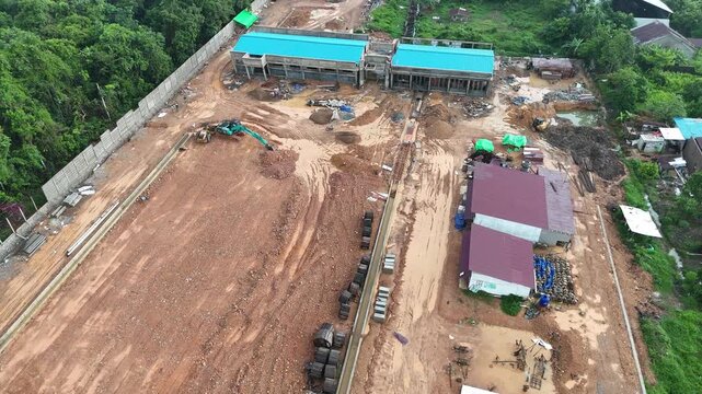 An aerial shot showing a muddy construction site with an excavator.