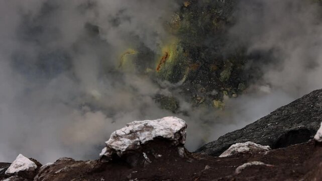 Inside Mount Bromo volcano crater with dense steam, sulfur deposits, and rugged volcanic terrain , East Java, Indonesia