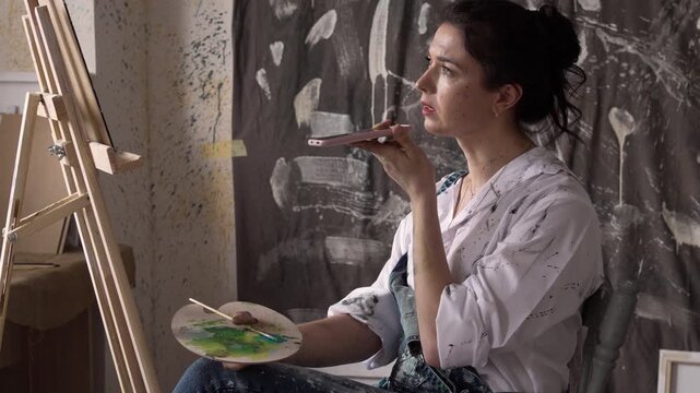 Woman painting using easel record audio message voice mail in modern art studio