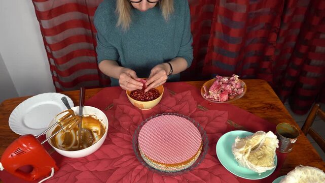 Woman peeling pomegranate. Hands with Fruits on the table. Cooking food at home