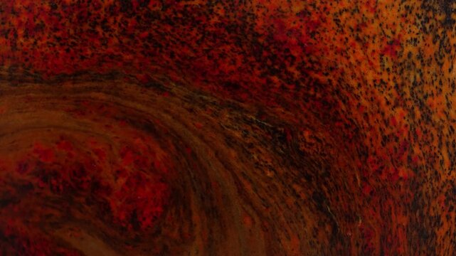 Abstract background with red liquid movement in macro view, black particles on red