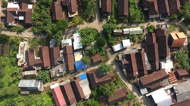 Aerial view of a traditional Indonesian village nestled at the foot of a majestic mountain.