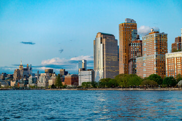 Fototapeta premium Midtown Manhattan skyline and Empire State Building from Battery Park. View of Midtown Manhattan towers including the Empire State Building across the trees of Battery Park City.