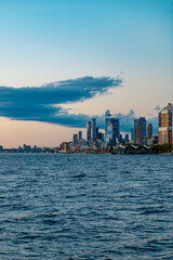 Obraz premium Hudson Yards skyline and West Side Manhattan from Hudson River. Wide angle view of the Hudson Yards development and Midtown West skyline under a large cloud at sunset.