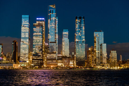 Hudson Yards district skyline with Vessel and illuminated towers. Close view of Hudson Yards New York featuring The Vessel and glowing residential buildings across the river at night.