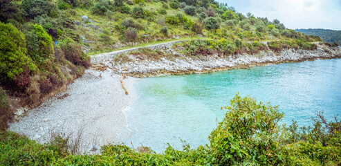 Primošten, Croatia: Rocky coastline with turquoise water and green vegetation © Elsworth Frobisher