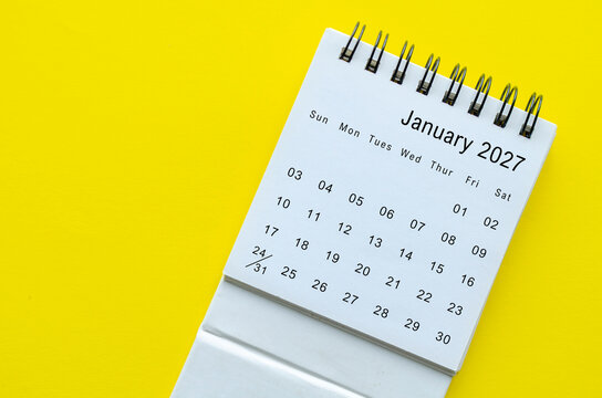 Top view of January 2027 calendar on yellow background with empty space for text.