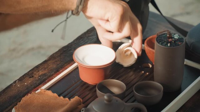Quietly serving warm tea moments. Relaxed coastal ritual with soft lighting and mindful sipping. Serene tradition involving gentle pouring of white tea into cups during peaceful coastal gatherings