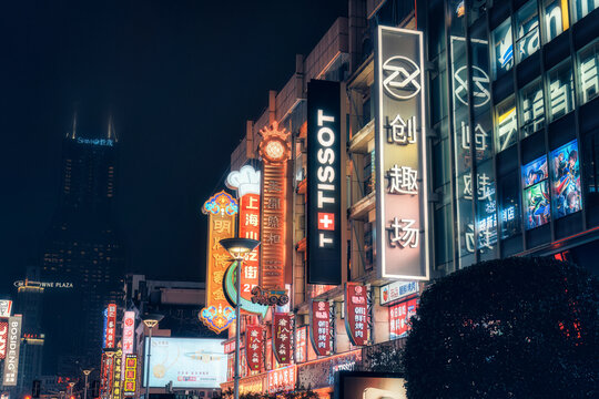 Dazzling display with commercial signage and chinese light boxes along Nanjing Road at night in Shanghai