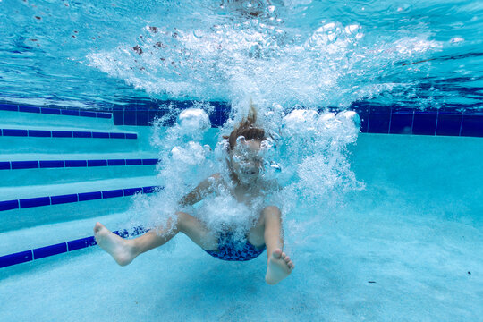 Young Boy Jumping in Pool