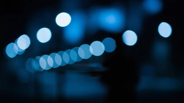Cool blue bokeh circles receding into the distance in a dark environment