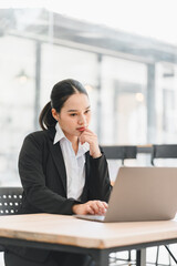 Fototapeta premium Business woman working on a laptop at a table in a modern office space