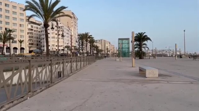 Walking POV Along Tangier Corniche Toward Marina with Palm Trees and Urban Buildings Morning Scene