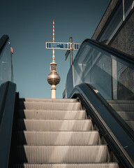 Berlin Fernsehturm TV Tower viewed from underground U-Bahn escalator at Alexanderplatz against clear blue sky © BERLIN-BELICHTET.DE