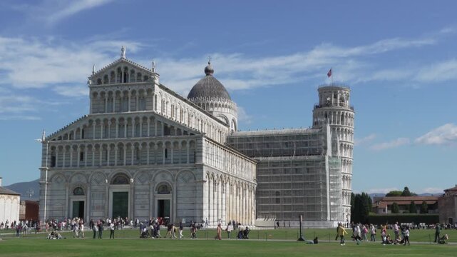 Tourists Walking in Pisa Cathedral Square Italy Travel Destination. Tourists walking near Pisa Cathedral in Piazza dei Miracoli, Italy. Famous travel destination with historic architecture.