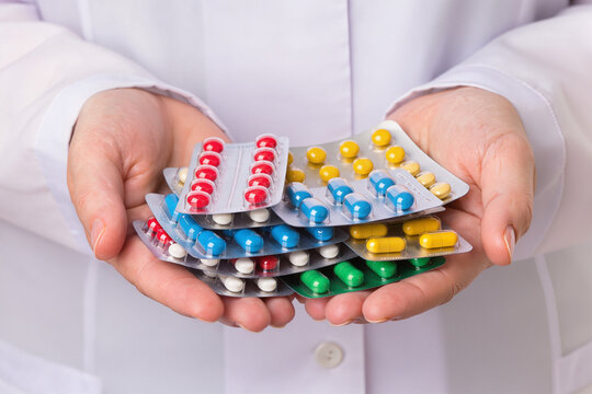 Medical worker presenting colorful blister packs filled with pills and capsules today.