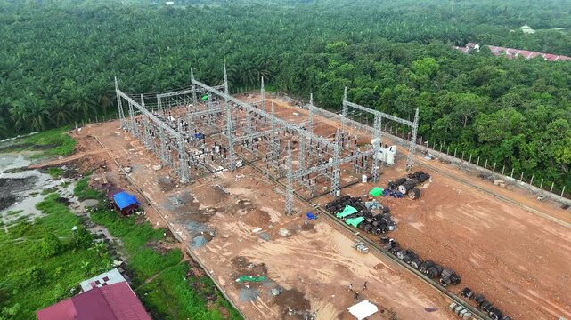 Aerial view of the electrical substation construction site, surrounded by tropical forest and a palm oil plantation currently under development.