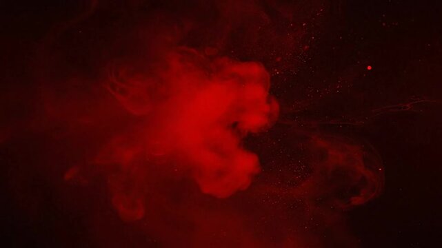 Abstract red ink spreading and swirling in dark water creating a mysterious and artistic background