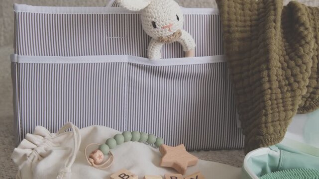 Assortment of newborn essentials, including a crib organizer, toys, and textiles, creating a calm scene