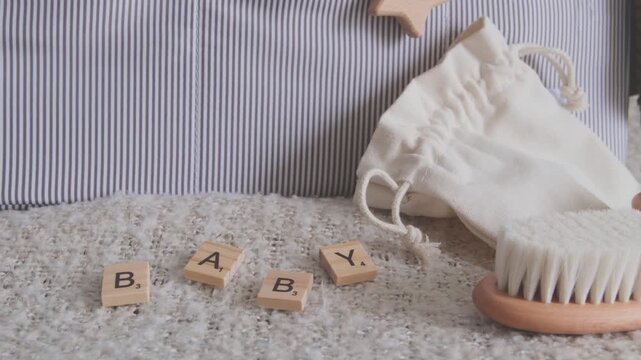 Cozy still life scene with newborn care items, wooden toys, and a fabric organizer for infants