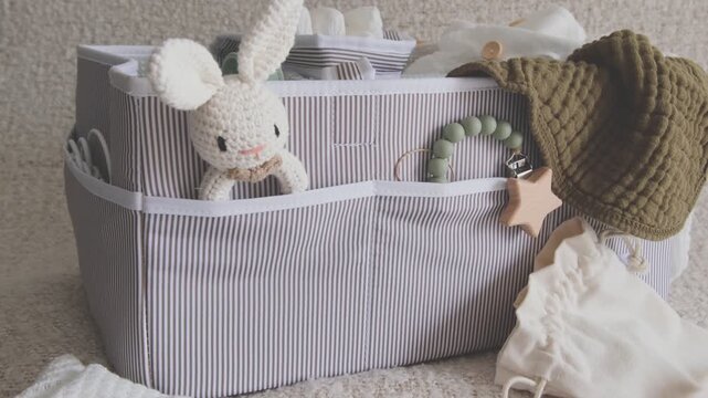Baby care essentials in a diaper caddy organizer with toys, clothes, and hygiene items