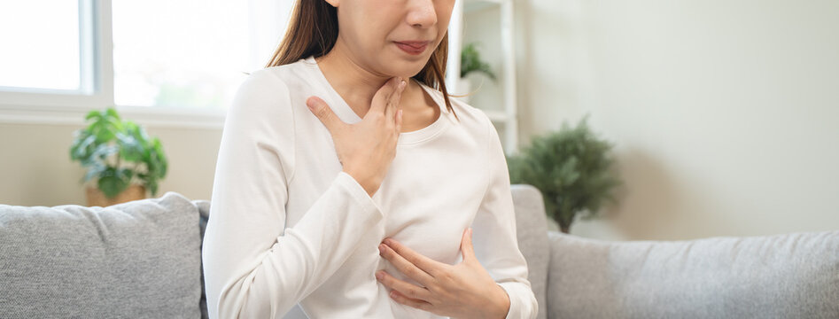 Acid reflux disease, suffer asian young woman have symptom gastroesophageal, esophageal, stomach ache and heartburn pain hand on chest from digestion problem after eat food, Healthcare medical concept