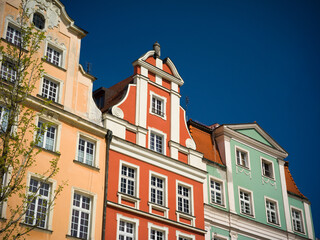 Obraz premium Wroclaw, Poland, 24th April 2026, old town market square in rynex with colourfull house facades and shop fronts of different colours against blue sky