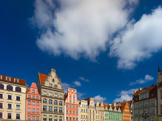 Fototapeta premium Wroclaw, Poland, 24th April 2026, old town market square in rynex with colourfull house facades and shop fronts of different colours against blue sky