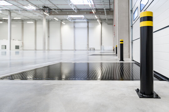 Interior of a Modern Empty Warehouse with Loading Docks and Safety Bollards