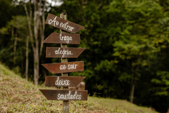 Placa "Ao entrar traga alegria, ao sair deixe saudade" em meio a mata