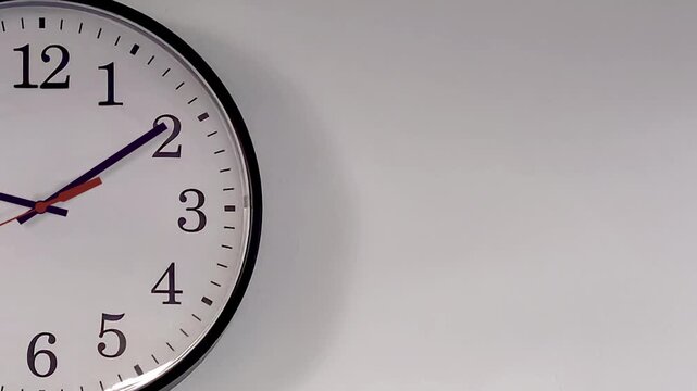 Half exposed analog wall clock spinning animation through the hours with space for copy