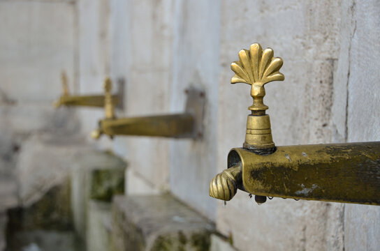 Traditional brass ablution tap at mosque for ritual washing in Islamic culture
