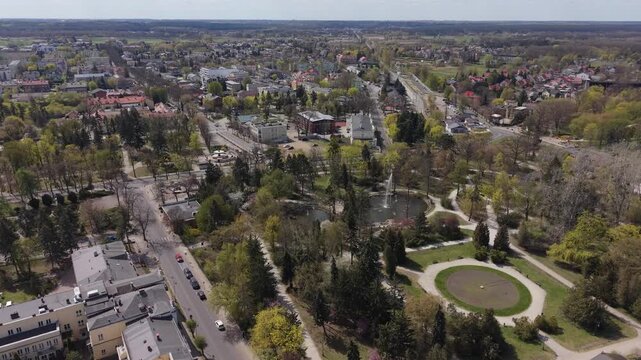Wide aerial view of the lush Zdrojowy Park with its fountain and town architecture in Ciechocinek, Poland
