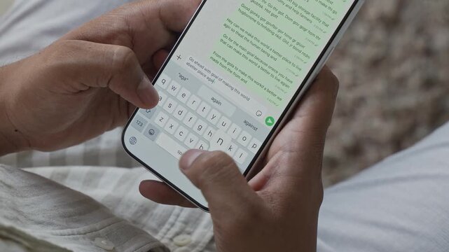 Close-up macro shot of anonymous male hands typing and chatting on a smartphone, fingers tapping a touchscreen keyboard while sending text messages in a modern digital environment. Unrecognizable pers