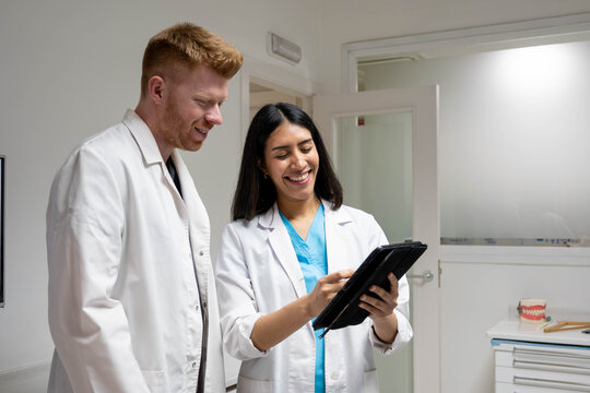 Dental team reviewing digital records on a tablet in a modern clinic