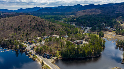 Obraz premium Long Lake, NY, USA April 29, 2026 Aerial photograph captures the scenic hamlet of Long Lake and Raquette River in the heart of New York's Adirondack Mountains.